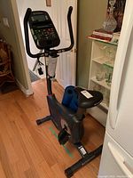 Full side view of Schwinn exercise bike with two blue mats rolled and placed on the frame below the seat.