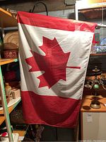Photo of Canadian flag attached to flag pole showing the red maple leaf design.