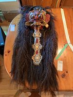 Full view of the Ranga mask showing detailed hair, face, and decorative elements.