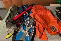 Photo showing Schwinn red and black bike pump, orange rain poncho, Black and clear diving masks, blue flippers, snorkels, and ski goggles
