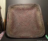 Top-down view of vintage woven rectangular basket showing the woven pattern and raised rim.