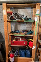 Full view of wooden shelf unit with various tools and items on shelves, showing structure and size.