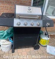 Full view of the Backyard Grill propane barbecue grill showing the four control knobs and side shelves.