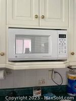 Front view of the white microwave showing the door, control panel and keypad