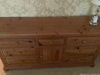 Full front view of the eight drawer pine dresser with visible wood grain and knots.