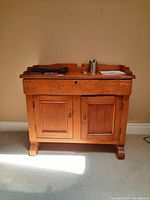 Wood cabinet with drawer and two doors from front view with items placed on top