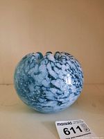 Front view of blue and white speckled glass art bowl, showing shape and pattern.