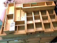Wooden drawer organizers with multiple compartments arranged on a surface.