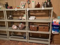 Two beige plastic storage shelves with various items on top and middle shelves to show structure and dimensions. Shelves have slatted design, four shelves each.
