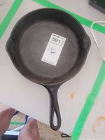 Top and inside view of cast iron skillet showing smooth cooking surface and handle with hanging hole.