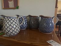 Four ceramic pitchers grouped together showing size and pattern variations
