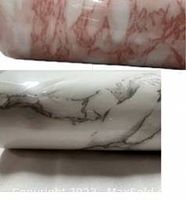 Close-up view of the two wallpaper rolls showing pink and white with grey marble patterns, indicating condition and pattern details.
