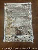 Full view of a clear plastic storage bag laid flat on a wooden surface showing the bag's size, thickness, and transparency.