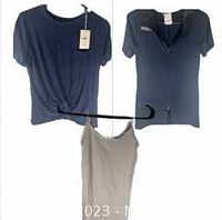 Photo showing three tops: navy blue knot tee with tag, navy blouse with POLO embroidery, beige camisole