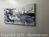 Photo of full abstract canvas wall art hung on a neutral colored wall showing overall design and color scheme.