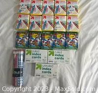 Overview photo showing all packs of crayons, index cards and pencils as arranged on a white surface.