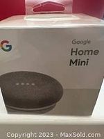 Front view of the box showing the Google Home Mini smart speaker in charcoal color and Google branding.