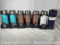 Seven insulated tumblers in blue, brown, black, and navy colors including six Sip by Swell and one Aladdin