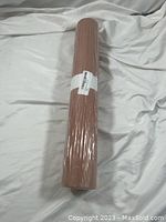 Full view of the butcher paper roll wrapped in clear plastic on a white cloth background.