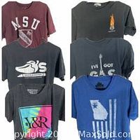 Front views of 6 different men's medium graphic t-shirts on hangers including maroon NSU, black swan, charcoal flame, navy 'I've Got Gas', blue Georgia flag, and blue with stripes images