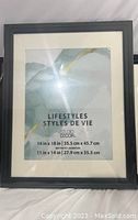 Front view of the black 14 x 18 inch photo frame with white mat showing 'Lifestyles Styles de Vie' text in window.