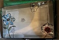 Photo of one rectangular platter showing hand painted blue flower on a gray background with a glossy reactive glaze finish.
