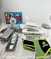 Full setup including Wii U console, GamePad controller, Super Mario Bros U game disc in case, Zumba Fitness game disc with belt, cables and power adapter.