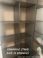 Close-up view of 16 black storage cubes forming a modular shelving unit, showing cubical compartments and metal corner connectors, example photo included showing configuration and color.