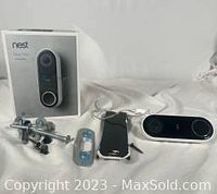 Photo showing Nest Hello video doorbell, mounting screws and brackets, wiring adapter, and original retail box.