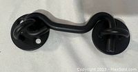 Photo of a fully assembled Raswik 4-inch privacy hook and eye latch showing curved hook and eye plates in matte black.