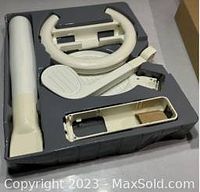 Top-down view of all five Wii Sports accessory pieces in molded packaging tray, showing baseball bat, golf club, tennis racket, driving wheel, and rectangular frame.
