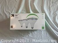 Photo of unopened white and green boxed pack of 3 LED flood light bulbs by Up & Up brand, front view.