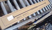 Photo showing the long rectangular box packaging with a simple illustration of the training stick and the color options (red or black)
