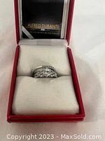 Top view of the stacking ring set inside a red Alfred Durante cushioned presentation box showing clear stones and silver-tone metal.