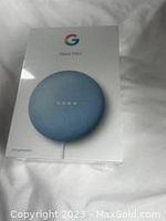 Front of the sealed Google Nest Mini box showing device image and Google logo.