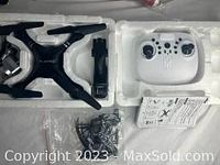 Unboxed HJHRC quadcopter drone and accessories packaged in foam, showing main drone body, remote controller, battery, and manual.