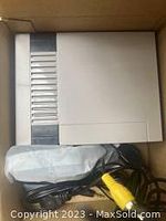 Photo of a single mini Nintendo style console in new condition inside box showing compact white plastic casing and AV cable.