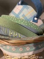 Close-up of green woven basket rim, fabric coating with 'HAPPY' embroidery
