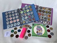 Several binders open showing rows of POGs with a pink slammer holder, loose POGs and a POG book titled 'Bad Hair Day' by Shaun O'Neil, illustrated by Alison Shauver.