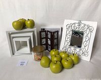 Photo showing all items including 3 square white wall shelves, white decorative mirror with ornate metal frame, 2 Umbra walnut shoji frames, new Marshmallow Fireside candle, and 10 decorative Granny Smith apples.