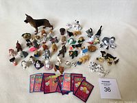 Photo showing a variety of Puppy in My Pocket dog figurines, cat figurines, rubber 101 Dalmatians figures, two small plastic beds, and Beethoven figurines.