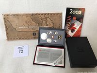 Photo of the three coin sets including 1988 commemorative set, Millennium set, and 2003 Polar Bear quarter with display packaging and certificate.