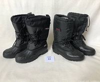 Two pairs of insulated women's winter boots placed side by side: Sorel in black and Baffin in black/grey, both size 10.