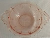 Top-down view of pink glass bowl showing the cherry blossom floral pattern and tab handles