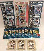 3 Wayne Gretzky special holder cards with 9 sealed 1992-93 Fleer Ultra packs, 2 sealed 1997-98 Upper Deck factory packs and 1 sealed 1997-98 Pacific factory pack displayed on table