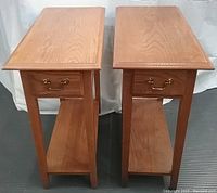 Top and side view of two oak side tables showing wood grain, single brass-handled drawer, and lower shelf.