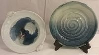 Frontal view of both pieces: swirl blue fade fish stamp plate and blue and white tab handle fish scale bowl.