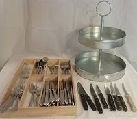 Full view of galvanized two-tier kitchen organizer with wooden flatware tray holding various pieces of flatware.