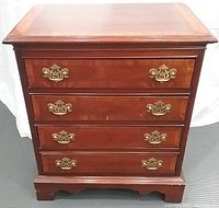 Front view of the 4 drawer mahogany side table showing brass hardware and inlay detail.