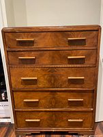 Front view showing the five drawers and wood grain pattern with wooden handles.